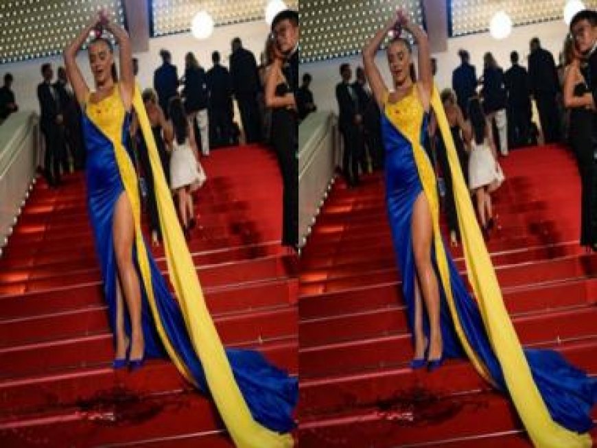 Woman draped in colours of the Ukrainian flag pours fake blood on herself at Cannes red carpet